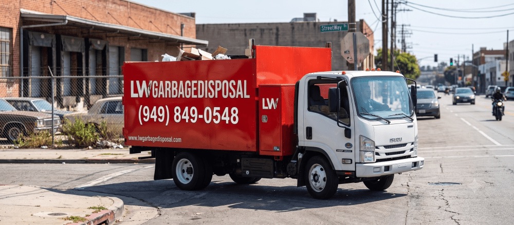 LW Garbage Disposal red junk removal truck parked on a Laguna Woods street, phone (949) 849-0548